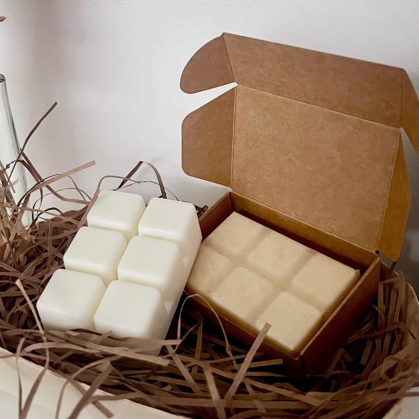 Casa De Lumière eco-luxury wax melts – biodegradable kraft box packaging with wax melt bar inside, presented on a bed of eco-friendly paper shred. Hand-poured in Cheshire, UK.